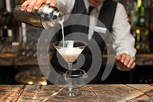 Barman at work, preparing cocktails. pouring pina colada to cocktail glass. photo