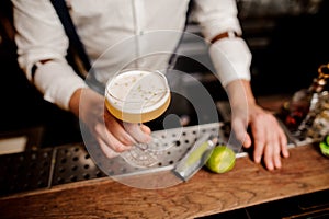 Barmans hands with coctail on the bar stand