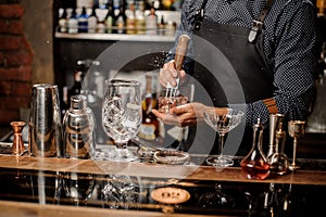 Barmans hands crushing a big ice cube