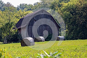 Barn captured in a countryside with covered hays in front of it