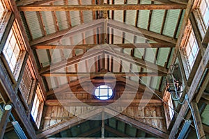 Barn ceiling with crossbeams and corrugated metal roof, circular window