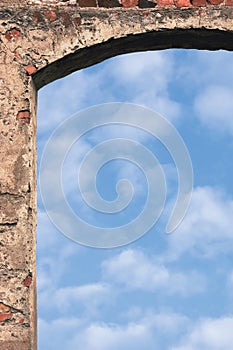 Barn gate door arch and sky, stone wall closeup, vertical bright white summer clouds cloudscape copy space background, plastered