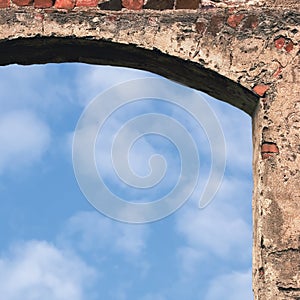 Barn gate door arch and sky, stone wall closeup, vertical bright white summer clouds cloudscape copy space background, plastered