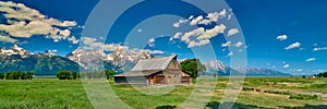 Barn with the Grand Teton mountains and blue sky at Grand Teton National Park
