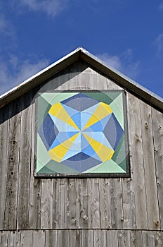 Barn quilt on old weathered building.
