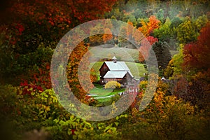 Barn in rural Vermont nestled between fall foliage