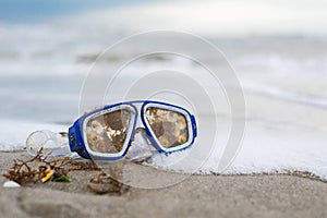 Barnacle Goggles on beach with a wave of sea foam