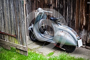 Barnfind old, rusty, used italian motorbike scooter on wooden wa