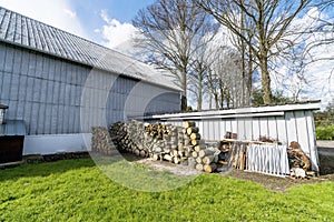 Barnyard with green grass and a woodstack