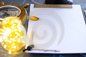 Barometer on a background of a white sheet of paper with lights in a glass jar.