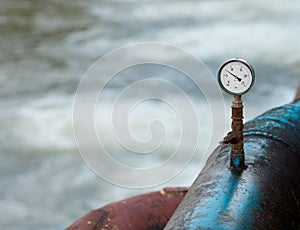 Barometer on a blue rusty water pipe