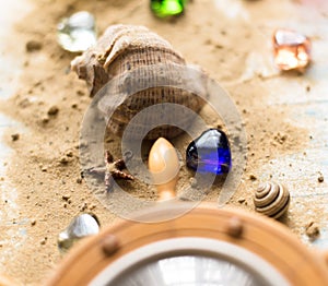Barometer with shell in the sand on a wooden background