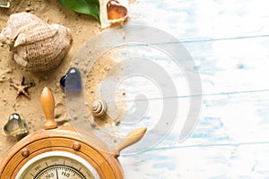 Barometer with shell in the sand on a wooden background