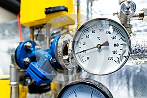 Barometers on pressure pipes, underground premises of the factory with heat and water distribution technology