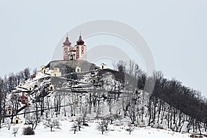 Barokní kalvárie v Banské Štiavnici, Slovensko, v zimní sezóně, zatažená obloha. Dolní, střední a horní kostel