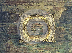 Baroque golden frame on wooden background. Grunge texture