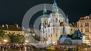 Baroque St. Nicholas' Cathedral on the Oldtown Square in Prague with monument Jan Hus illuminated at night timelapse