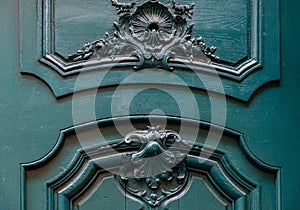 Baroque style sculptural details of gorgeous antique wooden door painted in beautiful aquatic blue color. Top part of vintage door