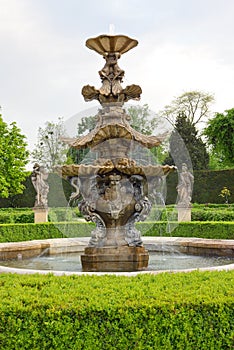 Baroque water fountain in green chateu garden