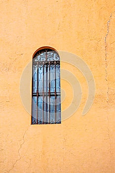 Barred, tall, window,set in, gold tone, concrete wall