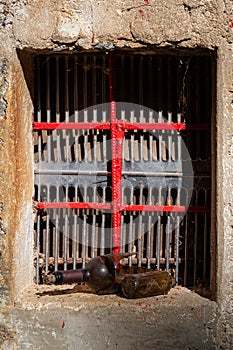 Barred window and a broken bottle on the sill