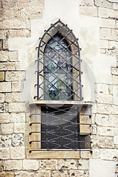 Zamřížované okno na zdi kostela
