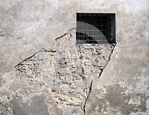 Barred window in eroded wall