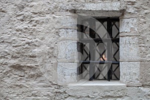 Barred window in an old stone house.
