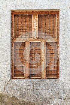 Barred window with wooden shutters in Oman