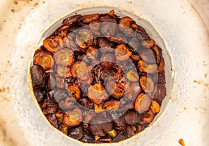 Barrel full of fermented plums for the production of real homemade plum brandy. Typically Czech fruit distillate spirit