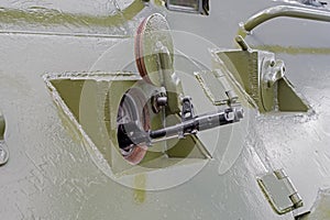 Barrel of machine in embrasure of armoured troop-carrier wheeled