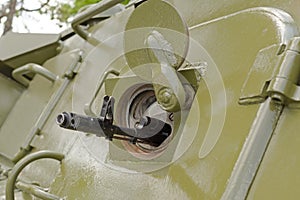 Barrel of machine in embrasure of armoured troop-carrier wheeled