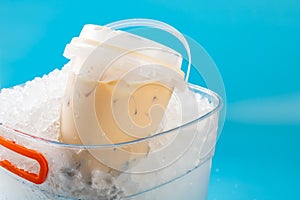 a barrel of milktea with tapiocas in an iced bucket at horizontal composition