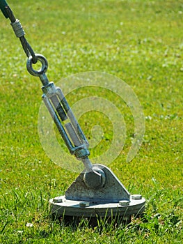 A barrel strainer anchored in grass.