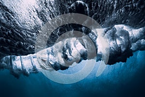 Barrel wave underwater with air bubbles.