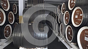 Barrels of cognac, wine or whiskey. Extract of brandy in oak barrels. Alcohol warehouse. Hundreds of barrels in an