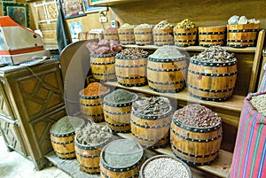 Barrels of spices and legumes for sale placed on shelves for sale in a souk