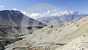 Barren landscape and snow-capped mountains on the trail from Muktinath to Kagbeni Annapurna Circuit Nepal