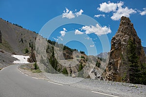 Barren rural landscape surrounds the scenic mountain road in the sunny Alps.