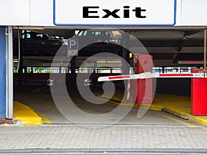 Barrier at the exit of a car parking garage with sign Exit
