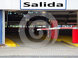 Barrier at the exit of a car parking garage with sign Salida