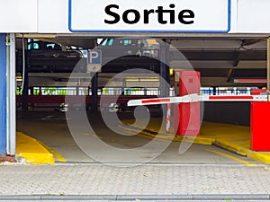 Barrier at the exit of a car parking garage with sign Sortie