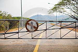 barrier Gate and Do not go straight direction old traffic sign on the road