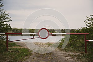 the barrier with a no entry sign . Road leads to the river