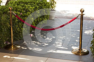 Barrier rope photo Golden stanchions with a red rope. Barrier, enclosed VIP area, protected entrance, private event, luxury gala