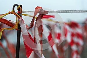 Barrier tape of plastic with red and white stripes fluttering in