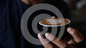 Barrista is making heart latte art on cappuccino.