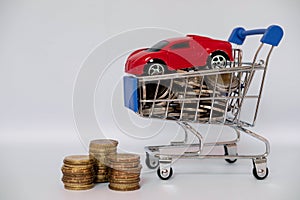 A barrow small shopping cart with coins on a white background for economizing  buying cars Concept of economizing and buying cars