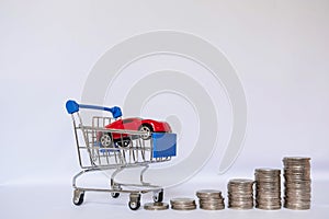 A barrow small shopping cart with coins on a white background for economizing  buying cars Concept of economizing and buying cars