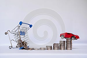 A barrow small shopping cart with coins on a white background for economizing  buying cars Concept of economizing and buying cars